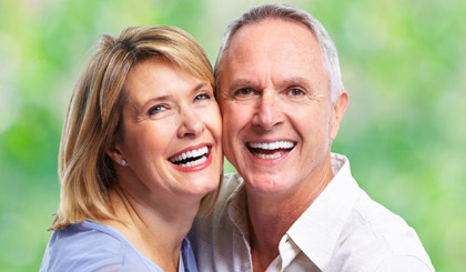 An elderly couple shows off their bright smiles highlighting the effects of teeth whitening.
